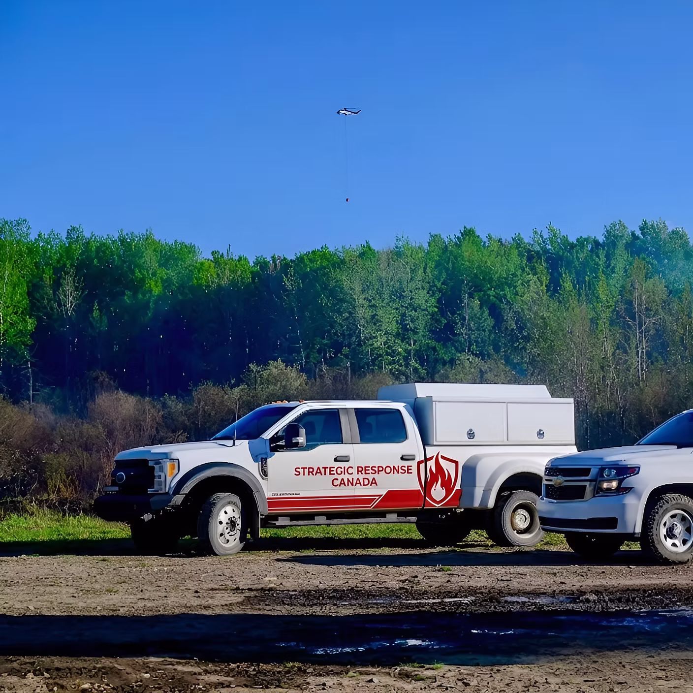 SRC branded field truck staged at a wildland fire site with a helicopter overhead